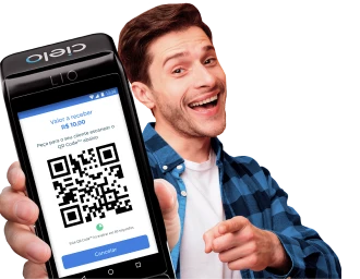 Empreendedor sorridente segura maquininha com QR Code para vender com Pix.