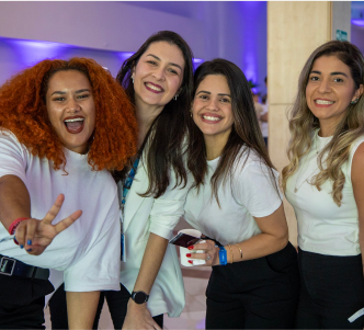 Quatro colaboradoras do Time Cielo de camisa branca estão sorrindo e fazendo pose para foto.